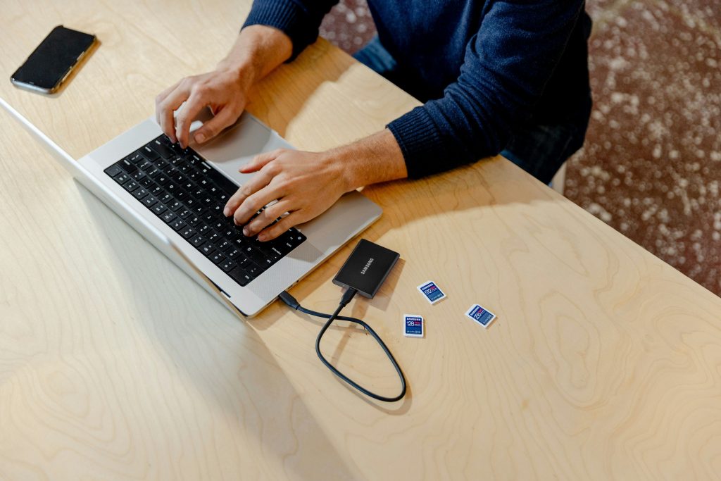 A person sitting at a table using a laptop computer